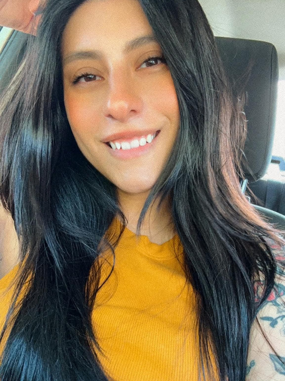 Alex Peña smiling in a yellow top