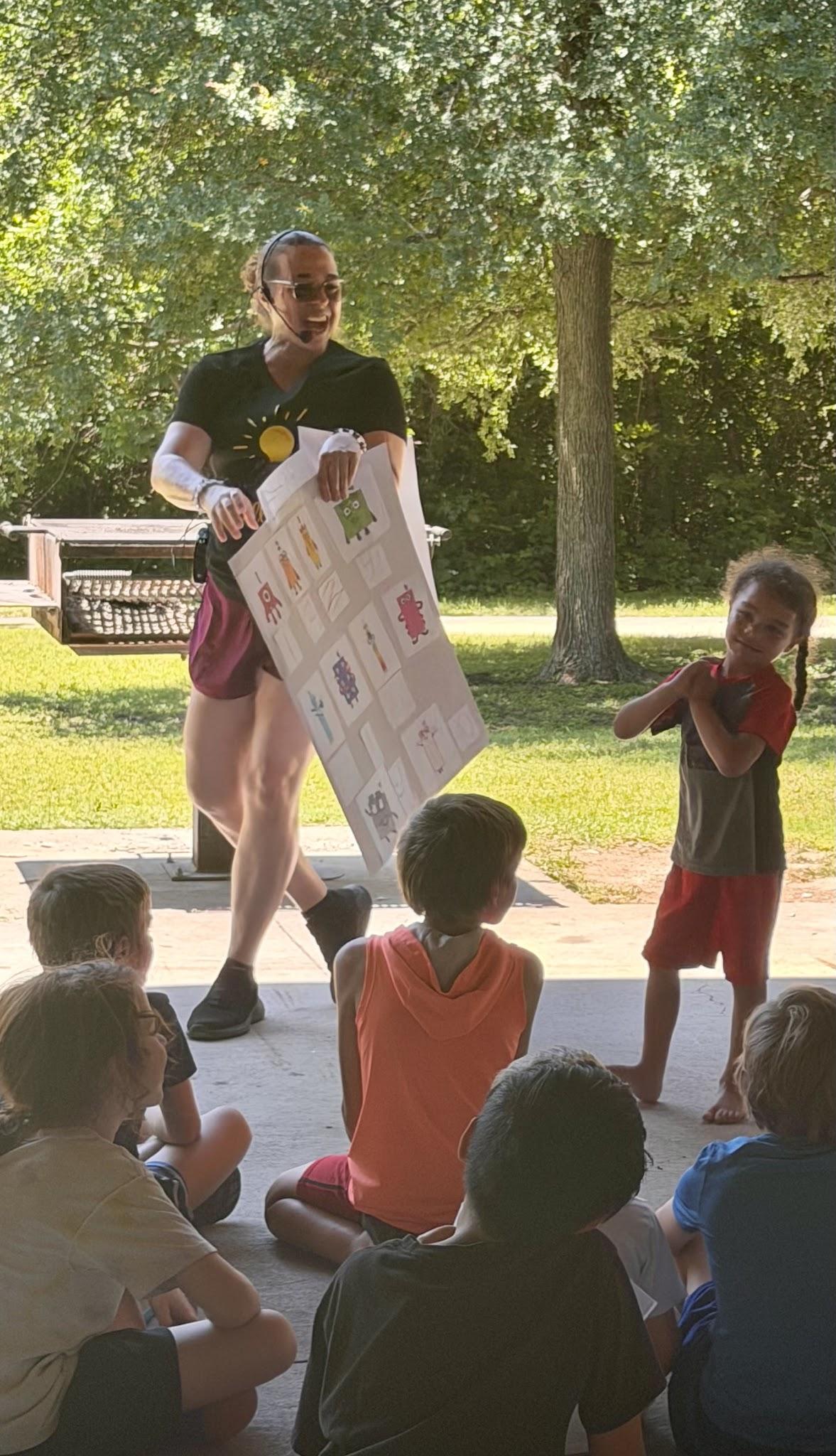 An adult leading an outdoor CurioSpark activity with children