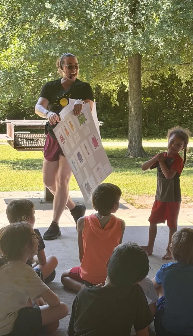 An adult leading an outdoor CurioSpark activity with children