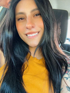 Alex Peña smiling in a yellow top